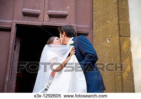 Newlyweds kissing outside church after wedding ceremony View Large Photo Image Stock Photography - Newlyweds kissing outside church after wedding ceremony. Fotosearch