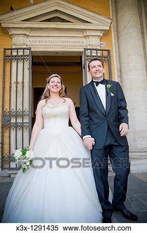 Stock Photography - Newlyweds leaving town hall on wedding day. Fotosearch