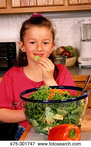 Nibbling on a piece of salad View Large Photo Image Stock Photo - Nibbling on a piece of salad. Fotosearch