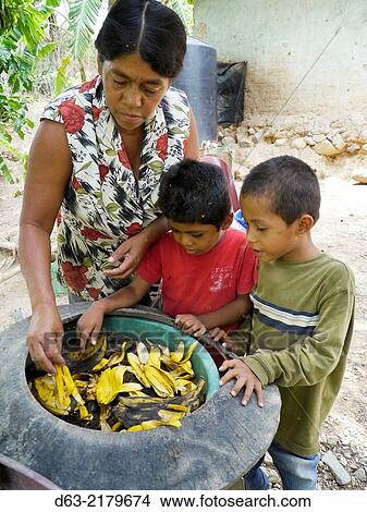 Nicaragua. FEDICAMP projects. Home of Reyna Margarita Vanegas (58) and her two sons Jose Armado Prado (4) and Junerling Prado (3). Worm culture for making compost. Reyna and the boys examine the pot in which the worms breed. View Large Photo Image Picture - Nicaragua. FEDICAMP projects. Home of Reyna Margarita Vanegas (58) and her two sons Jose Armado Prado (4) and Junerling Prado (3). Worm culture for making compost. Reyna and the boys examine the pot in which the worms breed.. Fotosearch