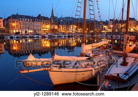 Stock Photograph - Night harbour scene with yachts and restaurant lights. Honfleur, Normandy, France.. Fotosearch