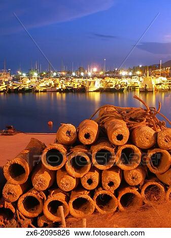 Stock Photograph - Night scene of Octopus pottery snare pile and Sailing Port at Sant Carles de la Rapita. Montsia Region, Tarragona Province, Catalonia, Spain.. Fotosearch