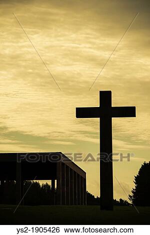 Stock Photograph - Night sky and silhouette of big christian cross and Chapel of the holy cross at skogskyrkogarden cemetery in Stockholm, Sweden. Fotosearch