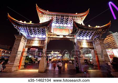 Picture - Night view of memorial arches of the Golden Horse and Jade Rooster in Jinmabiji Square, Kunming, China. Fotosearch
