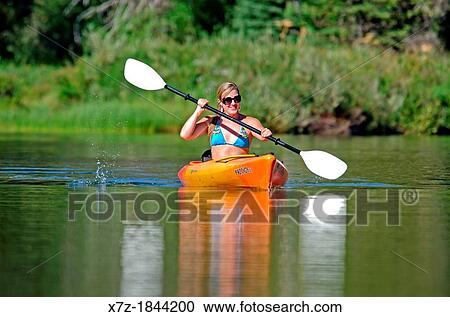 Stock Image - Nikki Tate kayaking on the North Fork of the Payette River near Payette Lake and the city of McCall in the Salmon River Mountains of central Idaho. Fotosearch