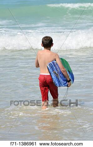 Nine year old boy playing in the surf on a body board Mimiwhangata Northland, New Zealand View Large Photo Image Stock Image - Nine year old boy playing in the surf on a body board Mimiwhangata Northland, New Zealand. Fotosearch