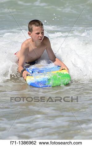 Nine year old boy playing in the surf on a body board Mimiwhangata Northland, New Zealand View Large Photo Image Stock Image - Nine year old boy playing in the surf on a body board Mimiwhangata Northland, New Zealand. Fotosearch