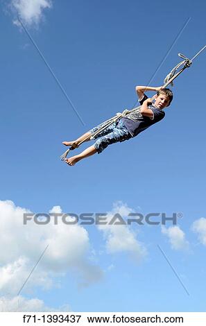 Nine year old boy swinging on a rope swing Atiamuri, New Zealand View Large Photo Image Stock Photo - Nine year old boy swinging on a rope swing Atiamuri, New Zealand. Fotosearch