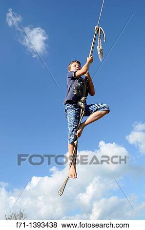 Nine year old boy swinging on a rope swing Atiamuri, New Zealand View Large Photo Image Stock Photo - Nine year old boy swinging on a rope swing Atiamuri, New Zealand. Fotosearch