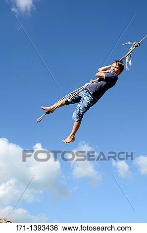 Nine Year Old Boy Swinging On A Rope Swing Atiamuri New Zealand Stock Photograph