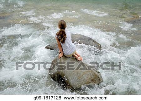 Nine year old girl sits on a large boulder and watches choppy waves, Barrow Bay, Ontario, Canada View Large Photo Image Stock Photo - Nine year old girl sits on a large boulder and watches choppy waves, Barrow Bay, Ontario, Canada. Fotosearch