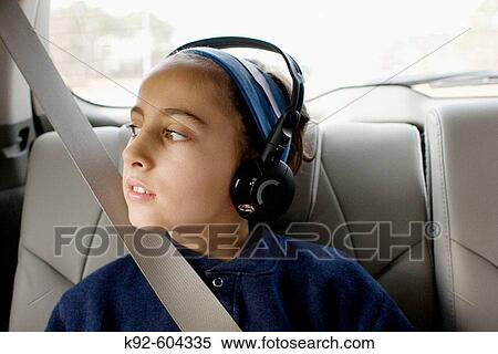 Nine year old girl with headphones looking out the window of a car. View Large Photo Image Stock Photography - Nine year old girl with headphones looking out the window of a car.. Fotosearch