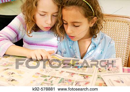Nine year old girls reading comics. View Large Photo Image Stock Image - Nine year old girls reading comics.. Fotosearch