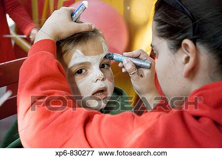 Stock Photo - Nio que le pintan la cara en una fiesta infantil. Fotosearch