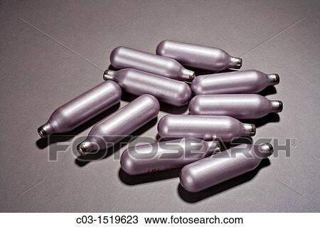 Stock Image - Nitrous-oxide N2O gas cartridges used to power a dessert whipped-cream charger as well as for for illegal inhalant pyschoactive effects. Fotosearch
