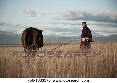 Nomad with his horse in Northern Mongolia. View Large Photo Image Stock Photograph - Nomad with his horse in Northern Mongolia.. Fotosearch