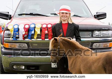 Stock Photo - North America, Canada, Ontario, girl with minature pony and ribbons at agricultural fair. Fotosearch