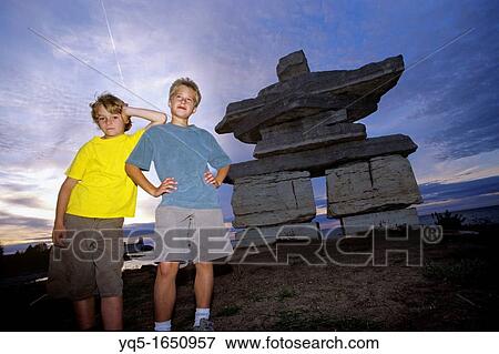 North America, Canada, Ontario, Collingwood, 2 boys standing in front of Inukshuk View Large Photo Image Stock Photo - North America, Canada, Ontario, Collingwood, 2 boys standing in front of Inukshuk. Fotosearch
