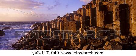 Stock Image - NORTHERN IRELAND, County Antrim, Giants Causeway Waves crash against the hexagonal basalts rock formations of this world heritage site. Fotosearch