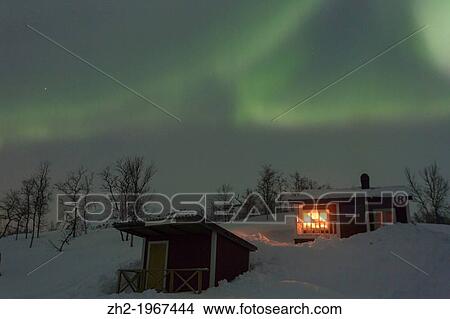 Northernlight, Aurora borealis, over a cottage with light coming through the window in winter season in march, in Riksgr? nsen, Swedish lapland, Sweden. View Large Photo Image Picture - Northernlight, Aurora borealis, over a cottage with light coming through the window in winter season in march, in Riksgr? nsen, Swedish lapland, Sweden.. Fotosearch