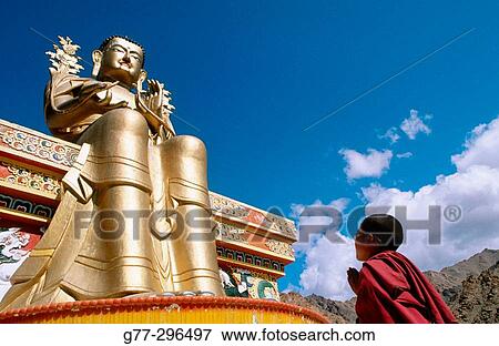 Novice monk praying in front of a giant buddha at Likir Monastery. Ladakh. Jammu and Kashmir, India View Large Photo Image Stock Photo - Novice monk praying in front of a giant buddha at Likir Monastery. Ladakh. Jammu and Kashmir, India. Fotosearch