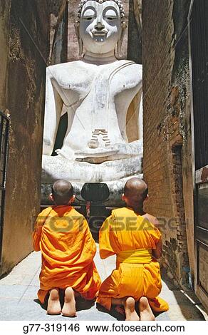 Novice monks Praying Buddha at temple Wat Si Chum. Sukhothai. Thailand View Large Photo Image Stock Photograph - Novice monks Praying Buddha at temple Wat Si Chum. Sukhothai. Thailand. Fotosearch