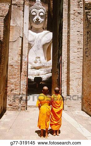 Stock Photography - Novice monks Praying Buddha at temple Wat Si Chum. Sukhothai. Thailand. Fotosearch