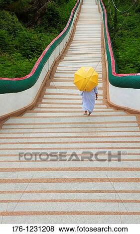 nun walks down long stairs at Wat Phra Phuttabat outside of Khon Kaen, Thailand View Large Photo Image Stock Photo - nun walks down long stairs at Wat Phra Phuttabat outside of Khon Kaen, Thailand. Fotosearch