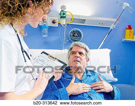 Stock Image - Nurse and patient in hospital room. Fotosearch