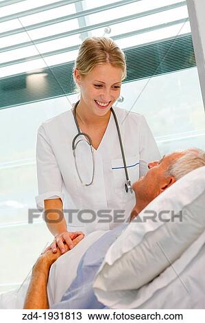 Stock Image - Nurse attending to patient in hospital room, Onkologikoa Hospital, Oncology Institute, Case Center for prevention, diagnosis and treatment of cancer, Donostia, San Sebastian, Gipuzkoa, Basque Country, Spain. Fotosearch