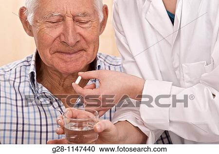 nurse hands giving a senior man his drug View Large Photo Image Stock Image - nurse hands giving a senior man his drug. Fotosearch