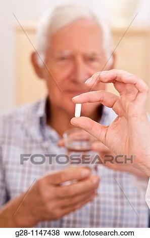 nurse hands giving a senior man his drug View Large Photo Image Stock Photo - nurse hands giving a senior man his drug. Fotosearch
