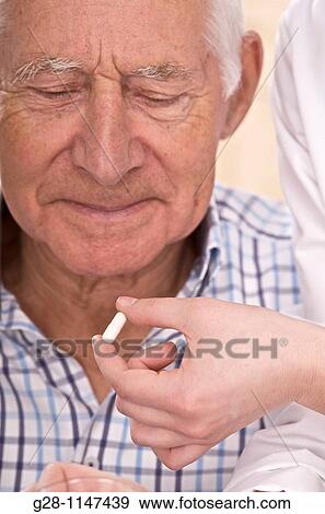 nurse hands giving a senior man his drug View Large Photo Image Stock Photo - nurse hands giving a senior man his drug. Fotosearch