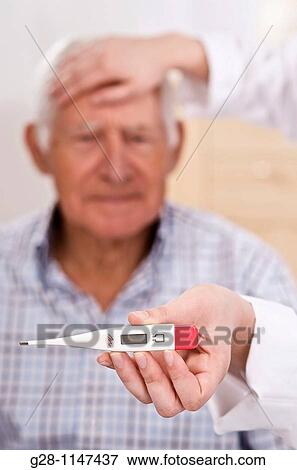 nurse hands hoding a thermometer and feeling a senior man forehead for temperature View Large Photo Image Stock Photo - nurse hands hoding a thermometer and feeling a senior man forehead for temperature. Fotosearch