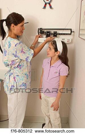 Nurse, measuring height of young girl View Large Photo Image Stock Image - Nurse, measuring height of young girl. Fotosearch
