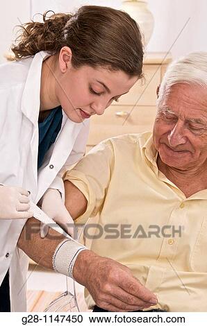 Nurse putting a bandage around a senior man arm View Large Photo Image Stock Image - Nurse putting a bandage around a senior man arm. Fotosearch