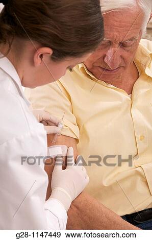 Nurse putting a bandage on a senior man arm View Large Photo Image Stock Photo - Nurse putting a bandage on a senior man arm. Fotosearch