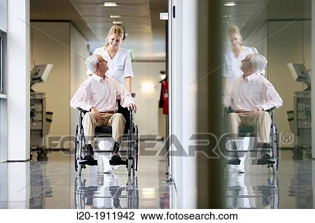 Stock Image - Nurse with patient in wheelchair, Corridor, Onkologikoa Hospital, Oncology Institute, Case Center for prevention, diagnosis and treatment of cancer, Donostia, San Sebastian, Gipuzkoa, Basque Country, Spain. Fotosearch