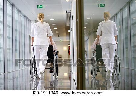 Stock Photograph - Nurse with patient in wheelchair, Corridor, Onkologikoa Hospital, Oncology Institute, Case Center for prevention, diagnosis and treatment of cancer, Donostia, San Sebastian, Gipuzkoa, Basque Country, Spain. Fotosearch