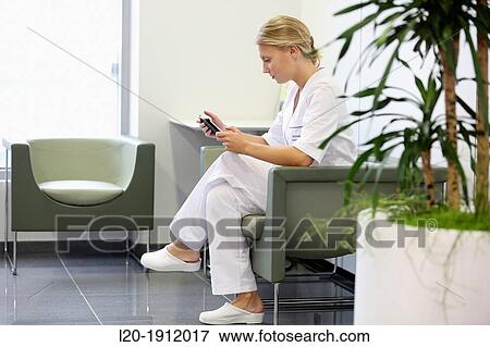 Stock Photo - Nurse with tablet, Waiting room, Onkologikoa Hospital, Oncology Institute, Case Center for prevention, diagnosis and treatment of cancer, Donostia, San Sebastian, Gipuzkoa, Basque Country, Spain. Fotosearch