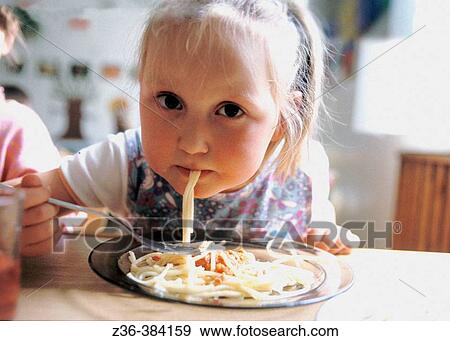 Nursery school. Gir eating spaghetti View Large Photo Image Stock Photo - Nursery school. Gir eating spaghetti. Fotosearch
