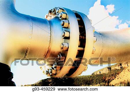 Stock Photo - Nuts and bolts holding together pipeline, sky in background. Fotosearch