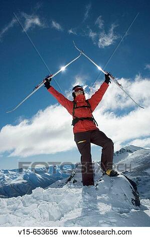 Stock Photograph - Off-piste skier on top of snow covered mountain with telemark skies. Fotosearch