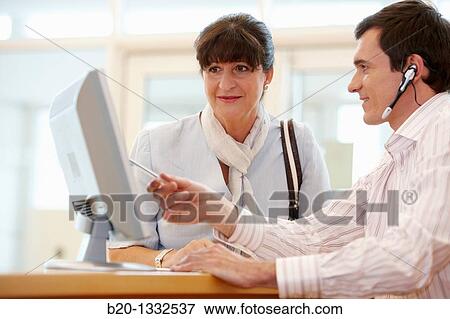 Office worker giving information to retired woman View Large Photo Image Stock Photo - Office worker giving information to retired woman. Fotosearch