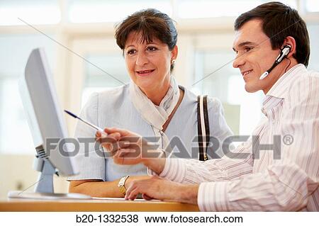 Office worker giving information to retired woman View Large Photo Image Stock Photo - Office worker giving information to retired woman. Fotosearch