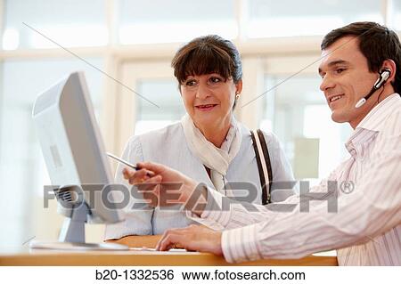 Office worker giving information to retired woman View Large Photo Image Stock Photograph - Office worker giving information to retired woman. Fotosearch