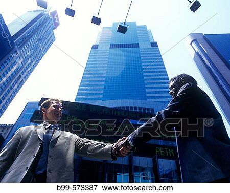 Office workers handshake by stock market ticker display. View Large Photo Image Stock Photo - Office workers handshake by stock market ticker display.. Fotosearch
