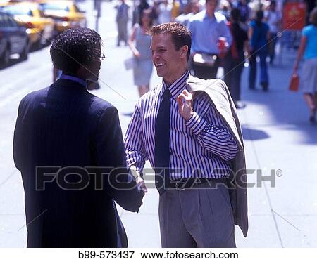 Stock Photo - Office workers shake hands, Fifth Avenue, Midtown, Manhattan, New York, USA. Fotosearch