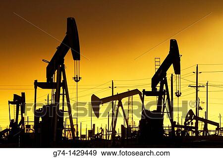 Stock Photo - Oil Pumps at work in oil and gas field USA. Fotosearch