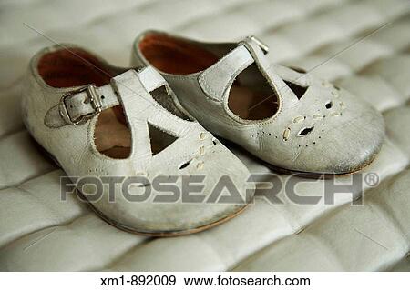 Stock Photo - Old baby's shoes on quilted material. Fotosearch